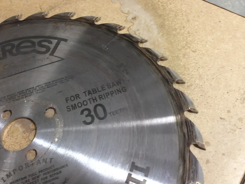 Circular saw blade displaying 30 teeth, placed on a wooden surface.